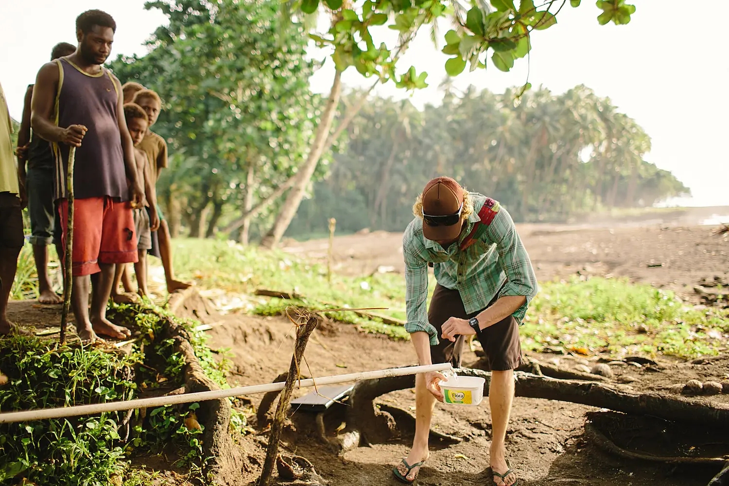 Jake Ward collects water in a bucket from a village tap on a beach in Makira. (10705805983)